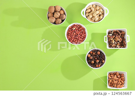 Assortment of assorted nuts with long shadows, healthy natural food concept, almonds, pecans, pistachios, cashews, walnuts and pine nuts, high calorie food with vegetable protein and vitamins, 124563667