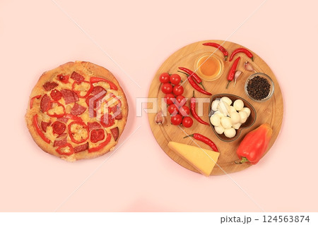 Pizza with ham, tomatoes, lemon, mozzarella, sauce, basil and cheese on a light background.Modern bakery concept, banner for menu or restaurant, top view, space for text. Selective focus Pizza with ham, tomatoes, lemon, mozzarella, sauce, basil and cheese on a light background.Modern bakery concept, banner for menu or restaurant, top view, space for text. Selective focus 124563874