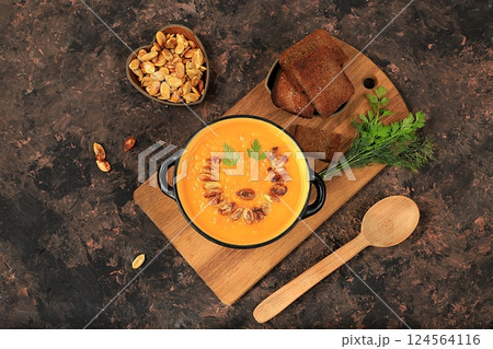 Pumpkin and zucchini cream soup with roasted seeds and toast,traditional autumn vegan food,healthy natural breakfast,advertising for cafe,restaurant,business card,selective focus 124564116