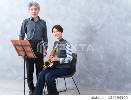 レッスンする大人の音楽教室の先生とサックスを教わる生徒 レッスンする大人の音楽教室の先生とサックスを教わる生徒 124564309