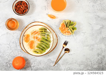 Healthy breakfast with ingredients, Rice pudding with kiwi, honey, tangerines and almonds.flat lay, Healthy and natural food concept, lifestyle, food for children, 124564323