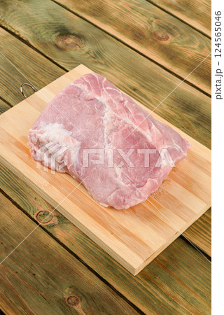 Top view of raw pork meat on wooden cutting board. Top view of raw pork meat on wooden cutting board. 124565046