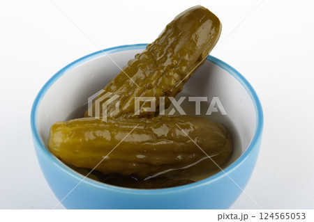 Homemade pickles in a bowl on a white background. Homemade pickles in a bowl on a white background. 124565053