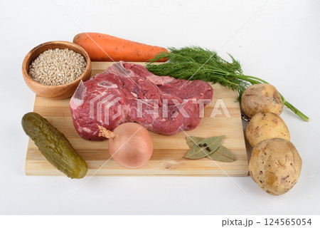 Raw meat on a cutting board and ingredients for making soup - Leningrad rassolnik. Raw meat on a cutting board and ingredients for making soup - Leningrad rassolnik. 124565054