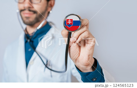 Doctor holding stethoscope with Slovakia flag. Slovakia health and care concept, Slovakia flag on stethoscope 124565123