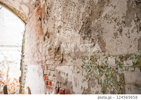 Chipped and flaking layers of lead based paint on the exterior of an old brick building 124565658