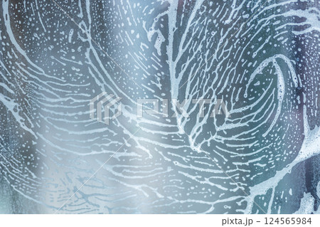 soap foam pattern wipe marks on window glass, window cleaning , blue background 124565984