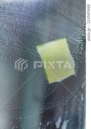 Сlose up of glass surface covered in soapy foam with sponge wiping it clean,highlighting texture Сlose up of glass surface covered in soapy foam with sponge wiping it clean,highlighting texture 124565988