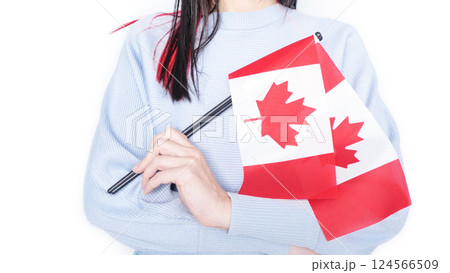 Unrecognized girl student in blue shirt holding small Canadian flag over gray background, Canada day, holiday, vote, immigration, tax, copy space Unrecognized girl student in blue shirt holding small Canadian flag over gray background, Canada day, holiday, vote, immigration, tax, copy space 124566509