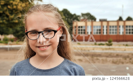 Smiling blonde 11 year old girl with glasses. 124566628
