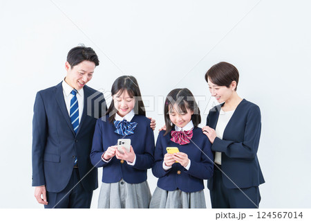 スマートフォンを使う女の子　見守る両親 124567014