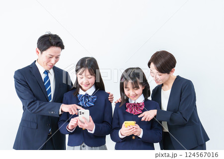 スマートフォンを使う女の子　見守る両親 124567016