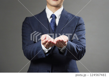 両手を差し出すビジネスマン　黒背景　顔無し 124567481