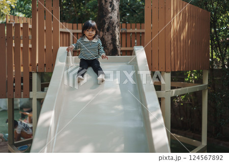 toddler baby girl sliding and playing at playground 124567892