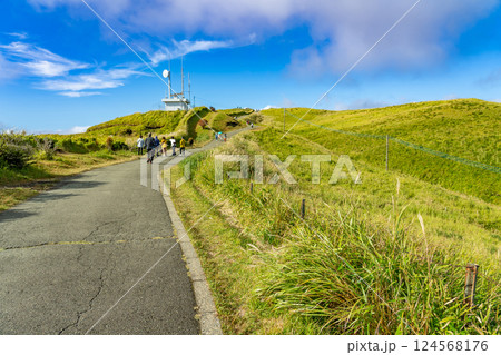 熊本県阿蘇市　秋の大観峰から眺める阿蘇のカルデラの遊歩道を散歩する観光客 124568176