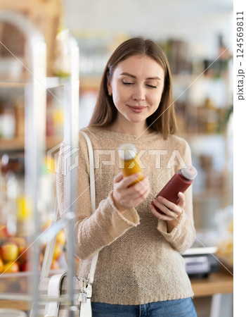 Portrait of young girl choosing smoothie products in supermarket Portrait of young girl choosing smoothie products in supermarket 124569811
