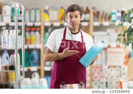 Adult male seller offering laundry detergent Adult male seller offering laundry detergent 124569849