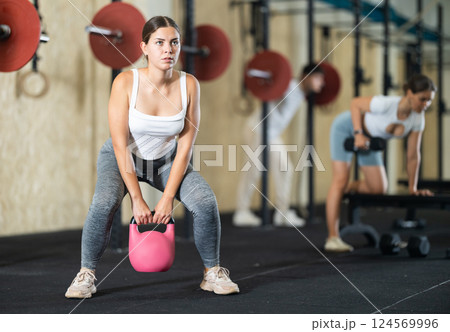 Young woman training with kettlebell in gym Young woman training with kettlebell in gym 124569996