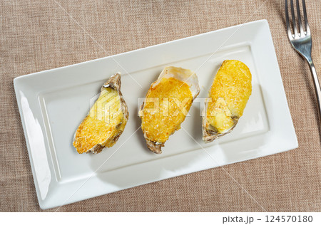 In center of photo are oysters served with aged Cava wine 124570180