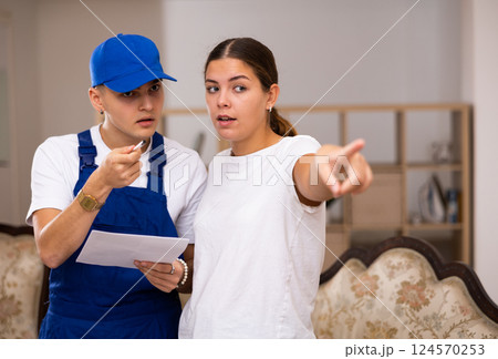 Master discusses with the young landlady of the apartment the plan of repair work Master discusses with the young landlady of the apartment the plan of repair work 124570253