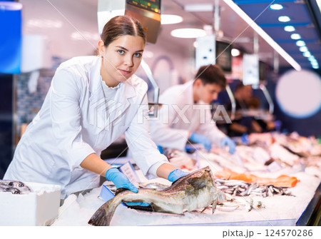Portrait of saleswoman offering fresh fish atlantic cod at shop 124570286