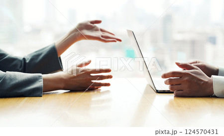 オフィスで都市を背景にノートパソコンとタブレットPCを使って作業する女性ビジネスパーソン 124570431