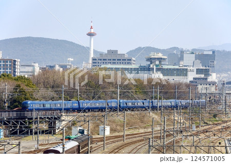 京都の街並みをバックに嵯峨野線を走る特急まいづる・はしだて 124571005