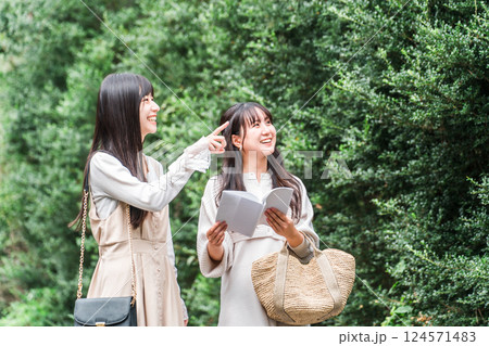 ガイドブックを見ながら観光地を歩く若いアジア人女性（女子旅・トラベル・観光） 124571483