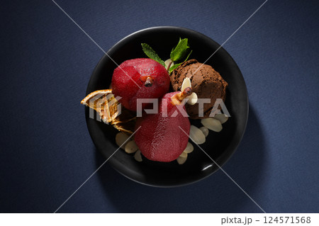 Ice cream and pears in wine on plate on dark blue background, top view 124571568
