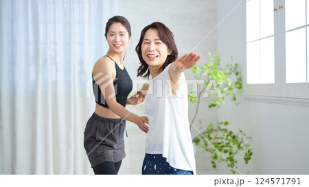 ヨガインストラクターにレッスンを受けるミドル女性 ヨガインストラクターにレッスンを受けるミドル女性 124571791