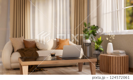 The laptop and coffee cup place on square wooden table in front of leather sofa. Earth tone interior The laptop and coffee cup place on square wooden table in front of leather sofa. Earth tone interior 124572061