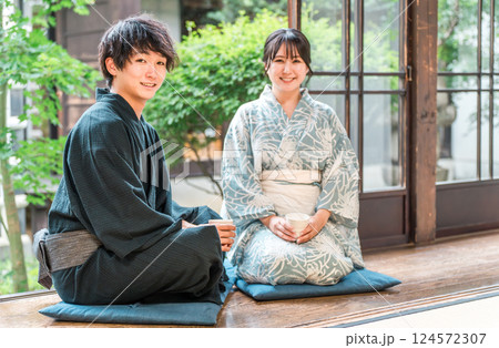 日本家屋の縁側に座る浴衣姿のアジア人カップル・夫婦 日本家屋の縁側に座る浴衣姿のアジア人カップル・夫婦 124572307