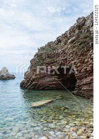Beautiful rocks and bright turquoise water among layered rocks near Budva, Montenegro. Tropical summer landscape exotic beach on the Adriatic Sea. Vacation 124572325
