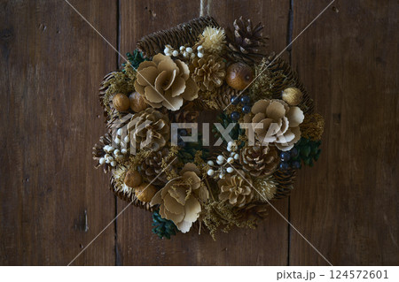 アンティークな木の壁に飾られたクリスマスリース 124572601