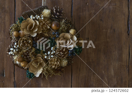 アンティークな木の壁に飾られたクリスマスリース 124572602