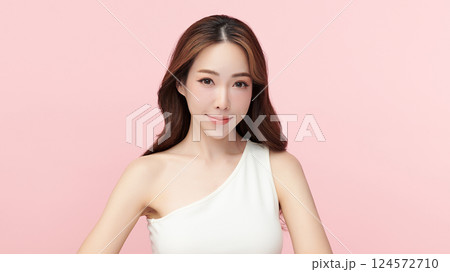 A beautiful young Asian woman with clean, fresh skin against a pink background. Skincare, facial treatment, cosmetology, beauty, and spa. An elegant portrait of an Asian woman. 124572710