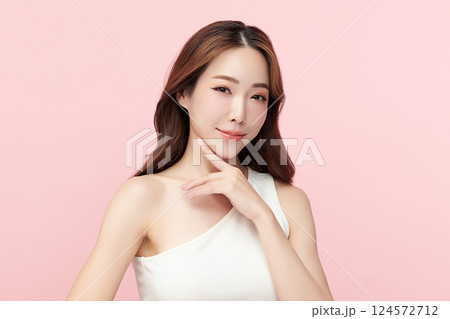 A beautiful young Asian woman with clean, fresh skin against a pink background. Skincare, facial treatment, cosmetology, beauty, and spa. An elegant portrait of an Asian woman. A beautiful young Asian woman with clean, fresh skin against a pink background. Skincare, facial treatment, cosmetology, beauty, and spa. An elegant portrait of an Asian woman. 124572712