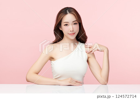 A beautiful young Asian woman with clean, fresh skin against a pink background. Skincare, facial treatment, cosmetology, beauty, and spa. An elegant portrait of an Asian woman. 124572714