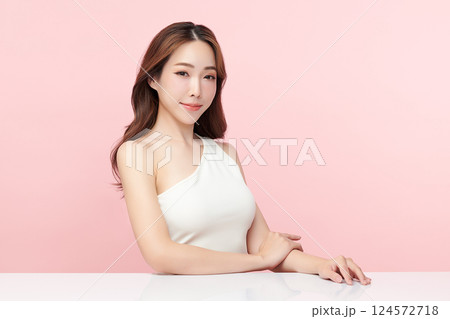 A beautiful young Asian woman with clean, fresh skin against a pink background. Skincare, facial treatment, cosmetology, beauty, and spa. An elegant portrait of an Asian woman. 124572718