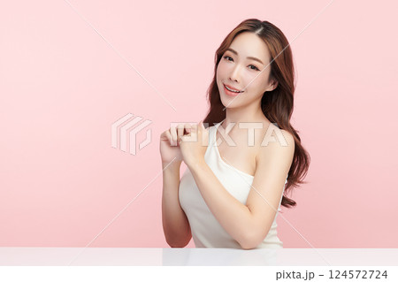 A beautiful young Asian woman with clean, fresh skin against a pink background. Skincare, facial treatment, cosmetology, beauty, and spa. An elegant portrait of an Asian woman. 124572724