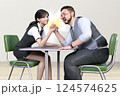 オフィスで男性社員と女性社員が腕相撲をしている 124574625