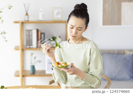 サラダを食べるのに飽きてしまった女性 124574660
