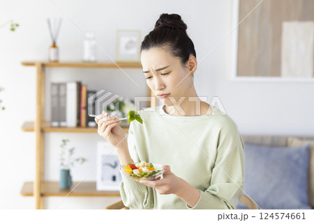 サラダを食べるのに飽きてしまった女性 124574661