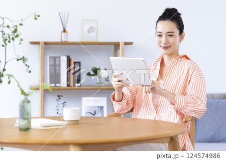 リビングでタブレットを見ている女性 リビングでタブレットを見ている女性 124574986