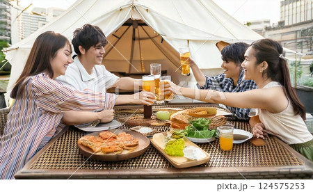 屋上ビヤガーデンで仲良く乾杯する男女4人 124575253