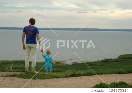 Father and Child Enjoying Scenic Lakeside View Father and Child Enjoying Scenic Lakeside View 124575514