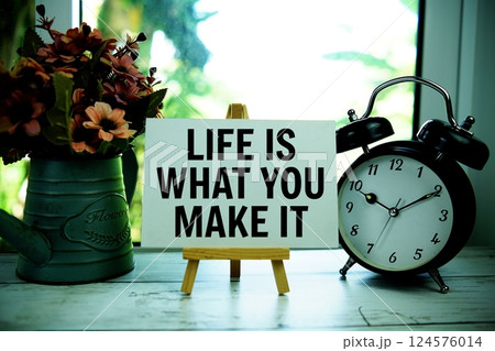 Life is what you make it text  motivational and inspiration quote with alarm clock on wooden background 124576014