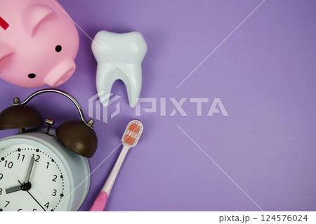 Toothbrush and White Tooth model with alarm clock dental hygiene concept on purple background 124576024