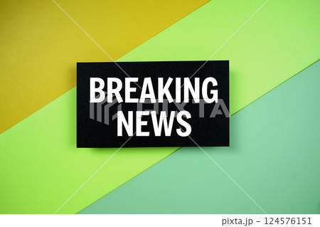 Breaking News text on paper card on green and yellow geometric background Breaking News text on paper card on green and yellow geometric background 124576151