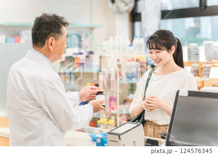 薬局に処方せん受け取り・買い物に来た女性 薬局に処方せん受け取り・買い物に来た女性 124576345